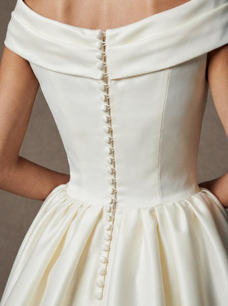 Margaux duchess satin ballgown wedding dress with a folded off-shoulder collar and covered buttons