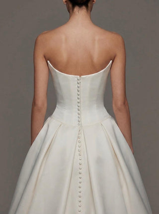 Made-to-measure Vivienne ballgown in duchess satin with a strapless scoop neckline and covered buttons